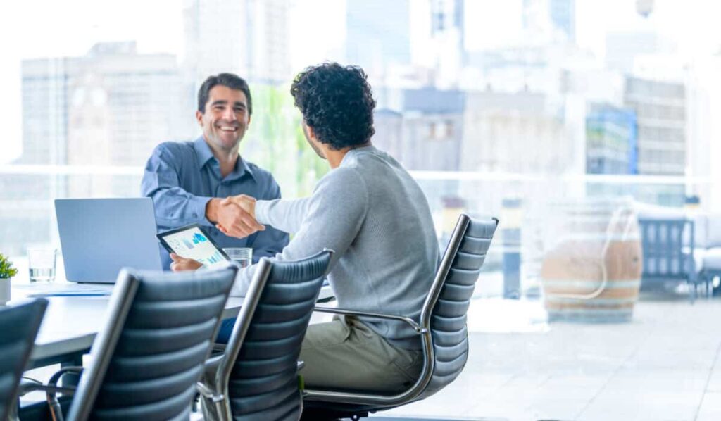 Carney’s Investment Summit: What Canadian Investors Need to Know businessmen shake hands to close a deal