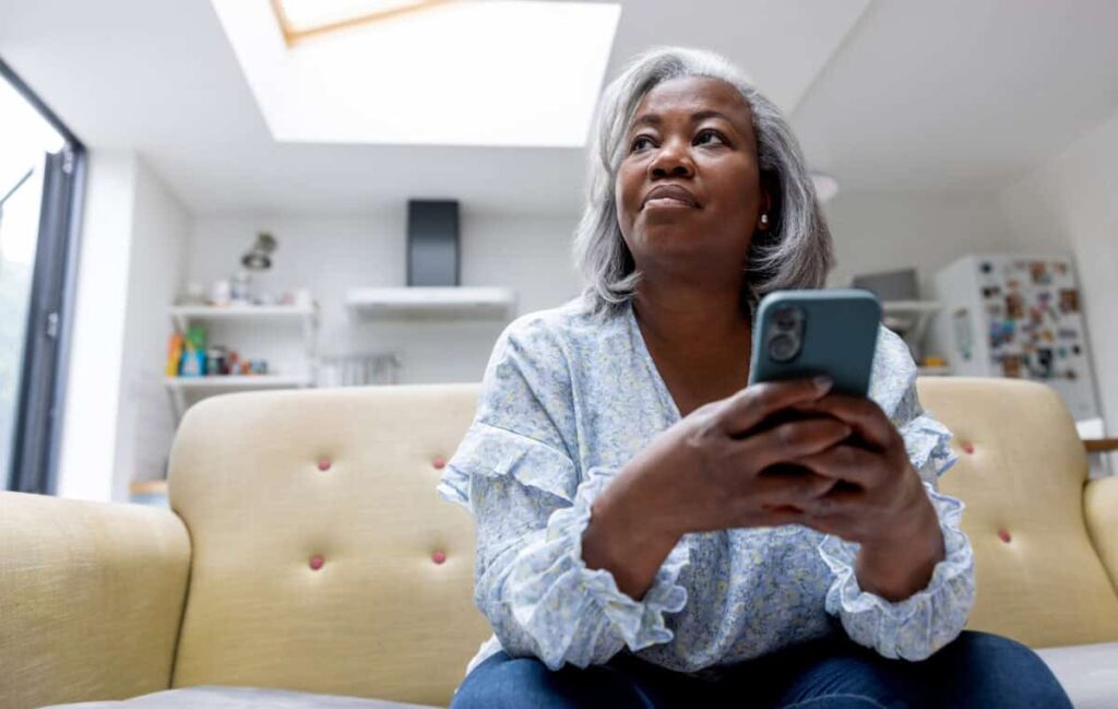 Is Telus a Good Stock to Buy Now? woman looks at iPhone